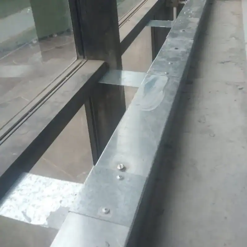 Metal track fire barrier at glazing base