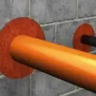 Orange pipe through a wall fire barrier seal